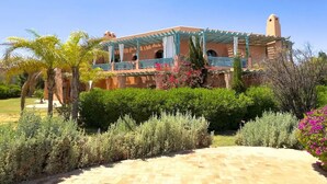 A two-story building with a covered patio and a tower. - Magnificent T2 with swimming pool (Marrakech)