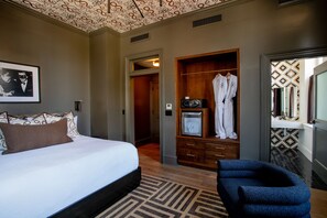 A hotel room with a large bed, a wardrobe, a seating area, and a bathroom visible through an open door. - The Bell Athens by Kasa Living (Athens)