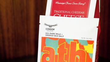 A package of condor chocolates with a colorful label and a box of Mississippi Cheese Scraw Factory Traditional Cheddar Cheese.