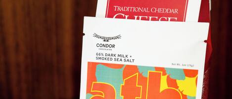 Un paquete de chocolates Condor con una etiqueta colorida y una caja de queso Cheddar tradicional de Mississippi Cheese Scraw Factory.