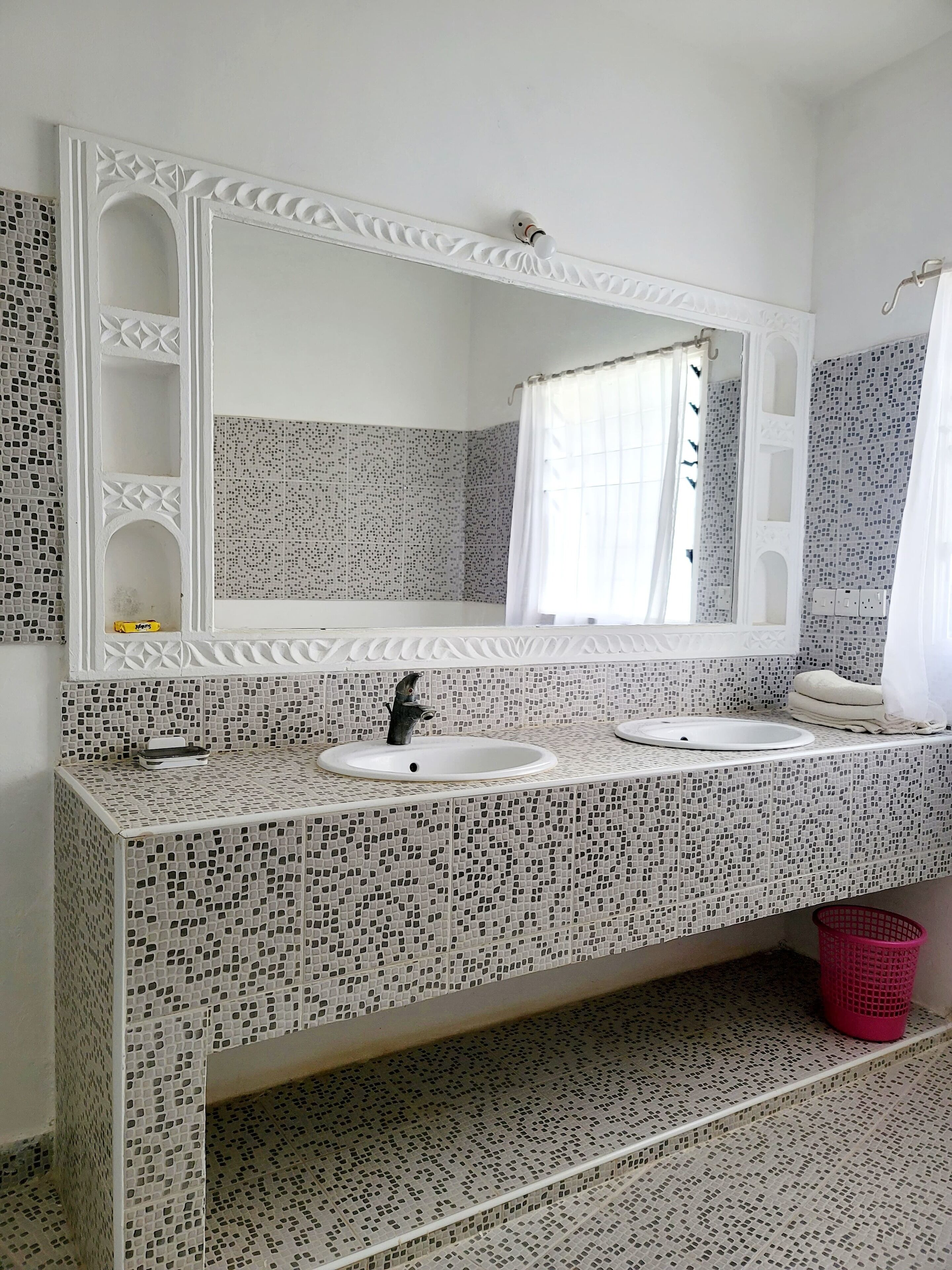 A bathroom with two sinks, a large mirror, and a shower curtain.
