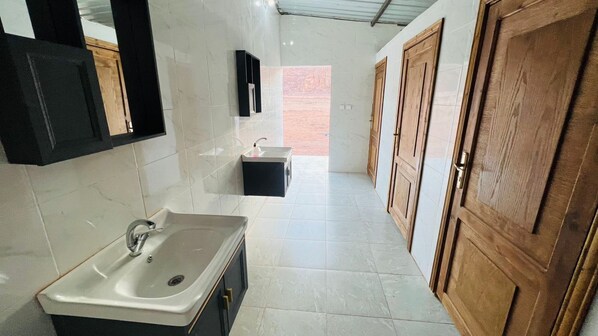 A modern bathroom with a sink, mirror, and cabinets.