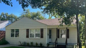 A single-story house with a front porch, a small front yard, and a tree to the right. - Rt 66 Retreat - Near Fairgrounds (Tulsa)