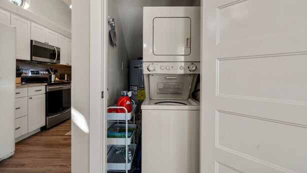 A compact kitchen with a microwave, stove, and a built-in washer-dryer unit.
