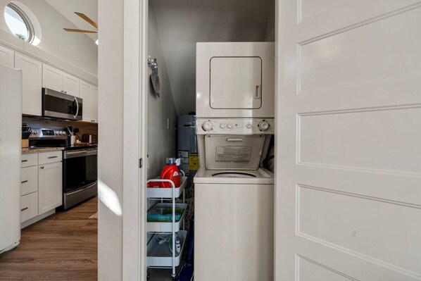 A compact kitchen with a microwave, stove, and a built-in washer-dryer unit.