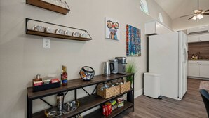 A modern kitchen with white cabinets, a coffee maker, and a microwave.