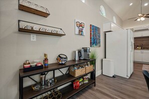 A modern kitchen with white cabinets, a coffee maker, and a microwave.