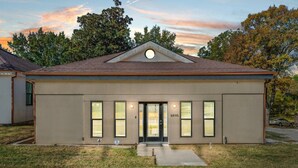 A single-story building with a gabled roof, a front door, and a small porch area.