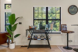 A room with a window, a chair, a table with items, and a plant. - Turkey Mountain Trailside by Tulsa Getaways (Tulsa)