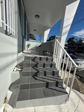 Stairs lead to an upper level with a potted plant below.