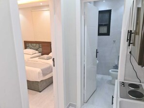 Cozy retreat with a single bed, bathroom, and shower area.