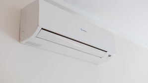 A white wall-mounted air conditioning unit with a control panel and a brand logo. - 1bed & Sofabed-seaside Apt-quiet Location-parking (Alicante)