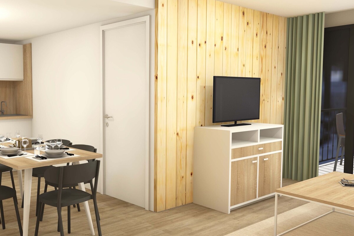 Een moderne keuken met witte kasten, een accentmuur van hout, en een eetgedeelte met een tafel gedekt voor vier personen.