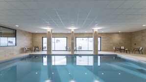 An indoor swimming pool with clear glass walls, tiled walls, and ceiling, and several chairs around the pool area. - Lagrange Vacances Le Cristal de Piau  (Aragnouet)