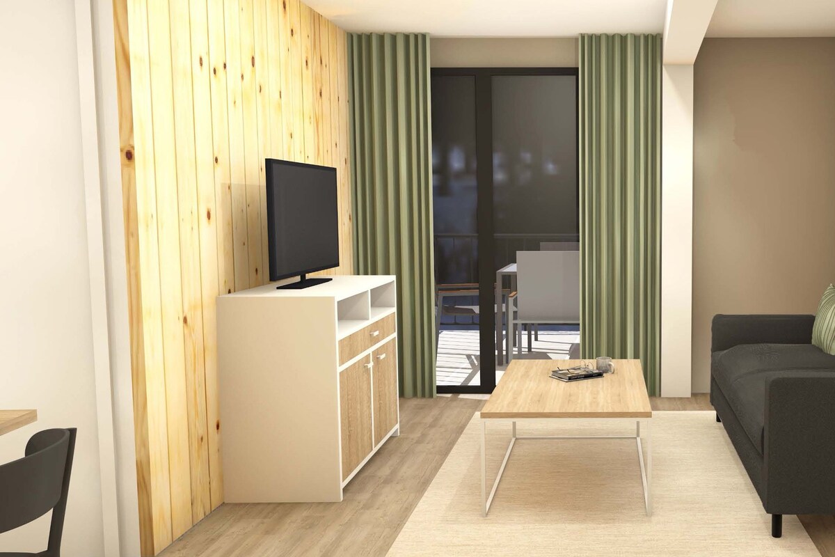 Een moderne woonkamer met een televisie, een bank, een salontafel en een schuifdeur naar een balkon.