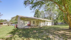 A single-story house with a porch, surrounded by a grassy yard and trees. - Hunting & Fishing Retreat in Marvell! (Marvell)