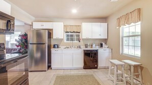 A modern kitchen with white cabinets, stainless steel appliances, and a central island. - Hunting & Fishing Retreat in Marvell! (Marvell)