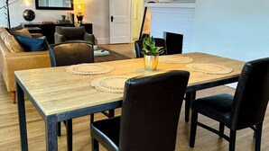 Ein Essbereich mit einem Holztisch, schwarzen Stühlen und einer schwarzen Pendelleuchte.