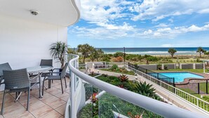 A balcony with a view of the beach, a pool, and outdoor furniture. - Surf Watch Palm Beach (Palm Beach)