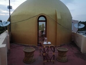 A dome-shaped building with a covered outdoor seating area featuring wicker furniture and satellite dishes. - Le Apex Guest House (Vanur)