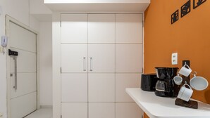 A kitchen with white cabinets, a white countertop, and a coffee maker. - Studio in Copacabana 5 Minutes From the Beach Nsc309 (Rio de Janeiro)