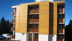 Un edificio de varios pisos con paneles de madera y balcones.