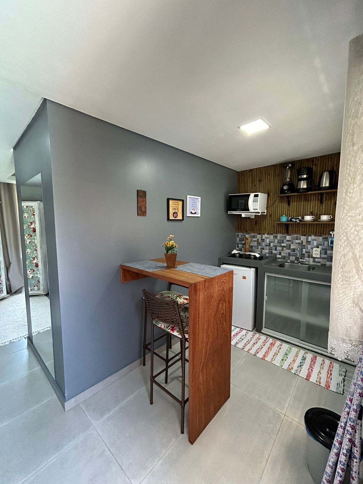 A compact kitchen with a wooden island, a microwave, and a coffee maker.