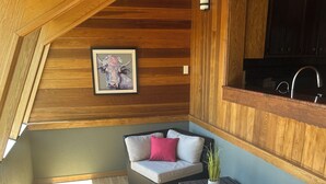 A cozy, wooden-paneled room with a dining area, a painting on the wall, and a view of the outdoors. - Discover your perfect getaway in this spacious 3-bedroom home in Cortez, CO!  (Cortez)