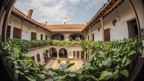 A courtyard with a central fountain, surrounded by arches and covered with greenery. - Spacious 9-bedroom apartment with WiFi, AC in awesome Cartagena (Cartagena)