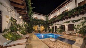 A courtyard with a swimming pool, lounge chairs, and potted plants. - Spacious 9-bedroom apartment with WiFi, AC in awesome Cartagena (Cartagena)