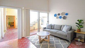 A modern living room with a grey sofa, a round coffee table, and a patterned rug. - Colorful Zen APTs 2 Blocks to the Beach (La Paz)