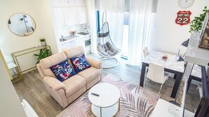 Ein modernes Wohnzimmer mit einer Couch, einem runden Couchtisch und einem Hängekorbstuhl.