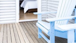 Une terrasse en bois avec un lit et une chaise bleue.