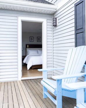 Une terrasse en bois avec un lit et une chaise bleue.