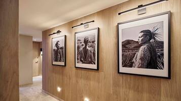 A hallway with framed black and white photographs on the wall.