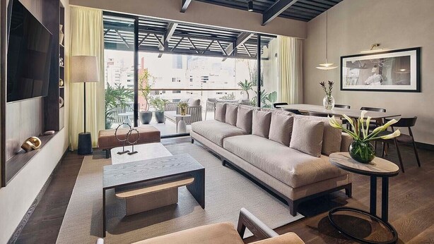 Ein modernes Wohnzimmer mit Sofa, Couchtisch und Essbereich.