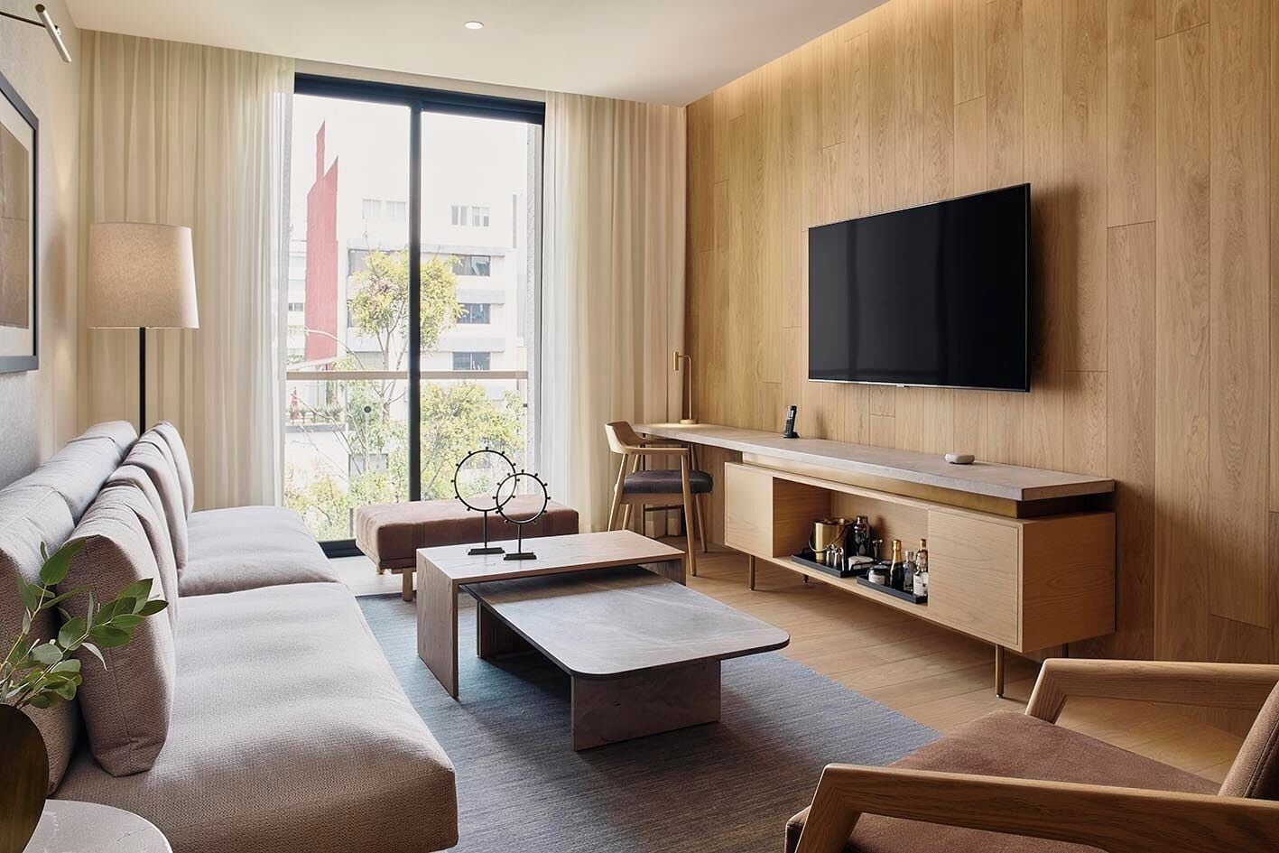 Una sala de estar moderna con un sofá, una mesa de centro y un televisor.