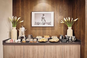 Ein reichhaltiges Frühstücksbuffet mit verschiedenen Speisen und einem gerahmten Bild an der Wand.