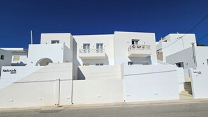 A modern white building with multiple balconies and a staircase leading to the entrance. - Aristotle Suites, Avgi (Adamantas)