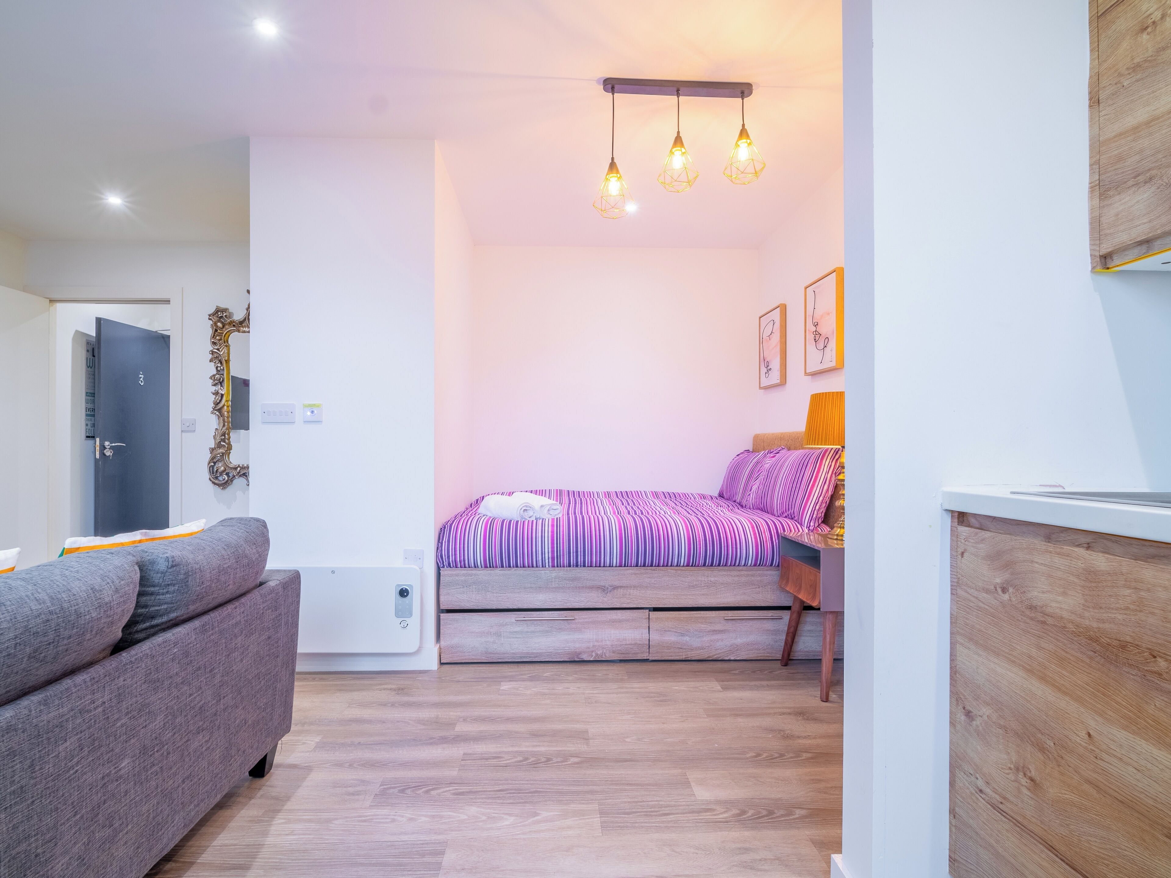 A modern bedroom with a bed, a sofa, and a wooden cabinet.