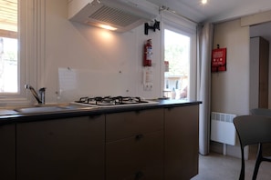 A kitchen with a gas stove, a sink, and a window.