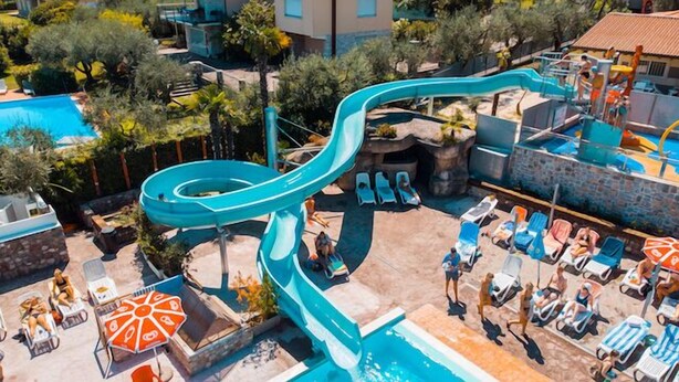 A water park with a large water slide, lounge chairs, and a pool area. - Internazionale Eden Mobilehome Happy Relax for 6 people (San Felice del Benaco)
