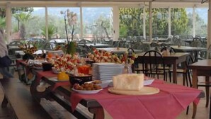 A buffet setup with various food items and a large window in the background. - Internazionale Eden Mobilehome Happy Relax for 6 people (San Felice del Benaco)