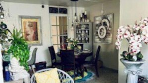 A dining area with a round table, chairs, and a decorative plant.