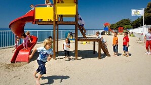 A beach playground with a slide and climbing structures. - Valamar Camping Lanterna Mobilehome Happy Superior J sea view for 7 persons (Tar)