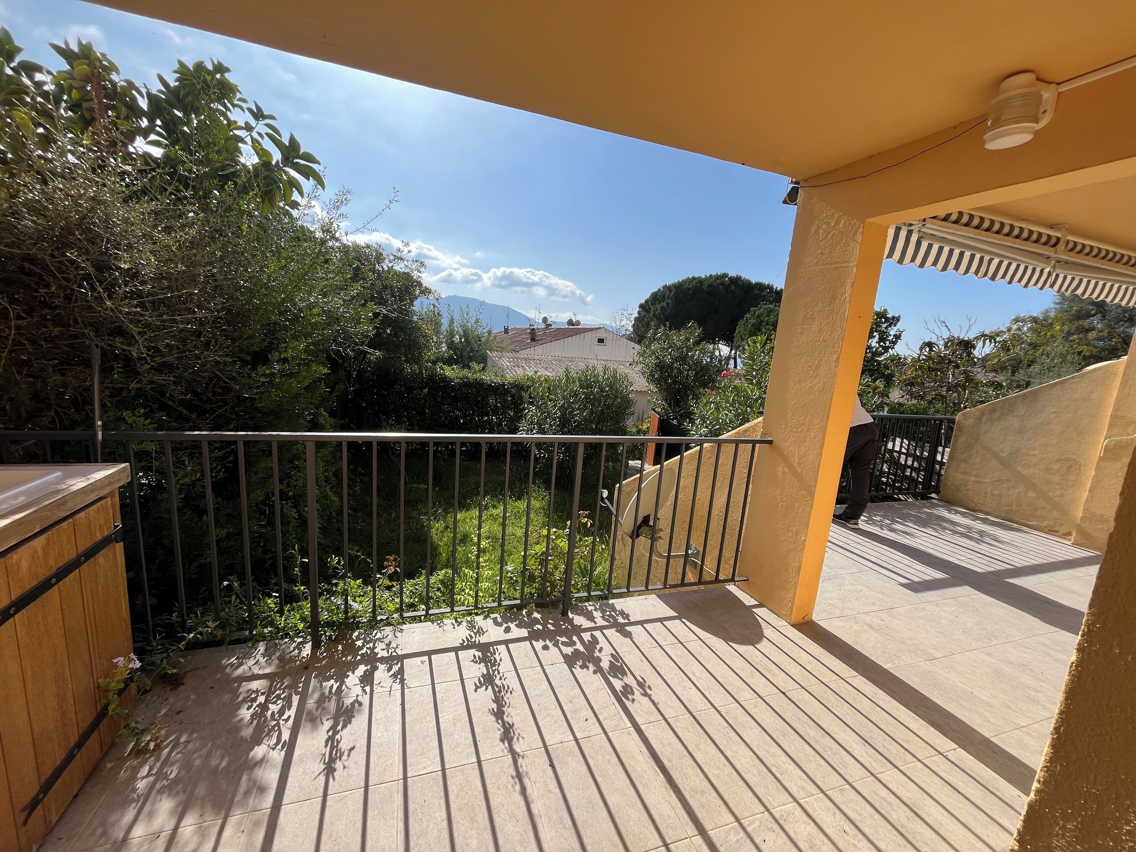 A balcony with a view of a mountain and trees.