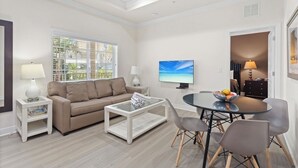 Un salon moderne comprenant un canapé, une table basse, un téléviseur et un coin repas.