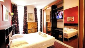 Een hotelkamer met een groot bed, een televisie en een spiegel.