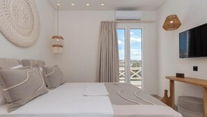 Ein modernes Schlafzimmer mit einem großen Bett, einem Flachbildfernseher und Blick auf die Stadt durch das Fenster.