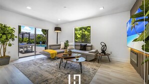 Ein modernes Wohnzimmer mit einer Couch, einem Couchtisch und einem Bild an der Wand.